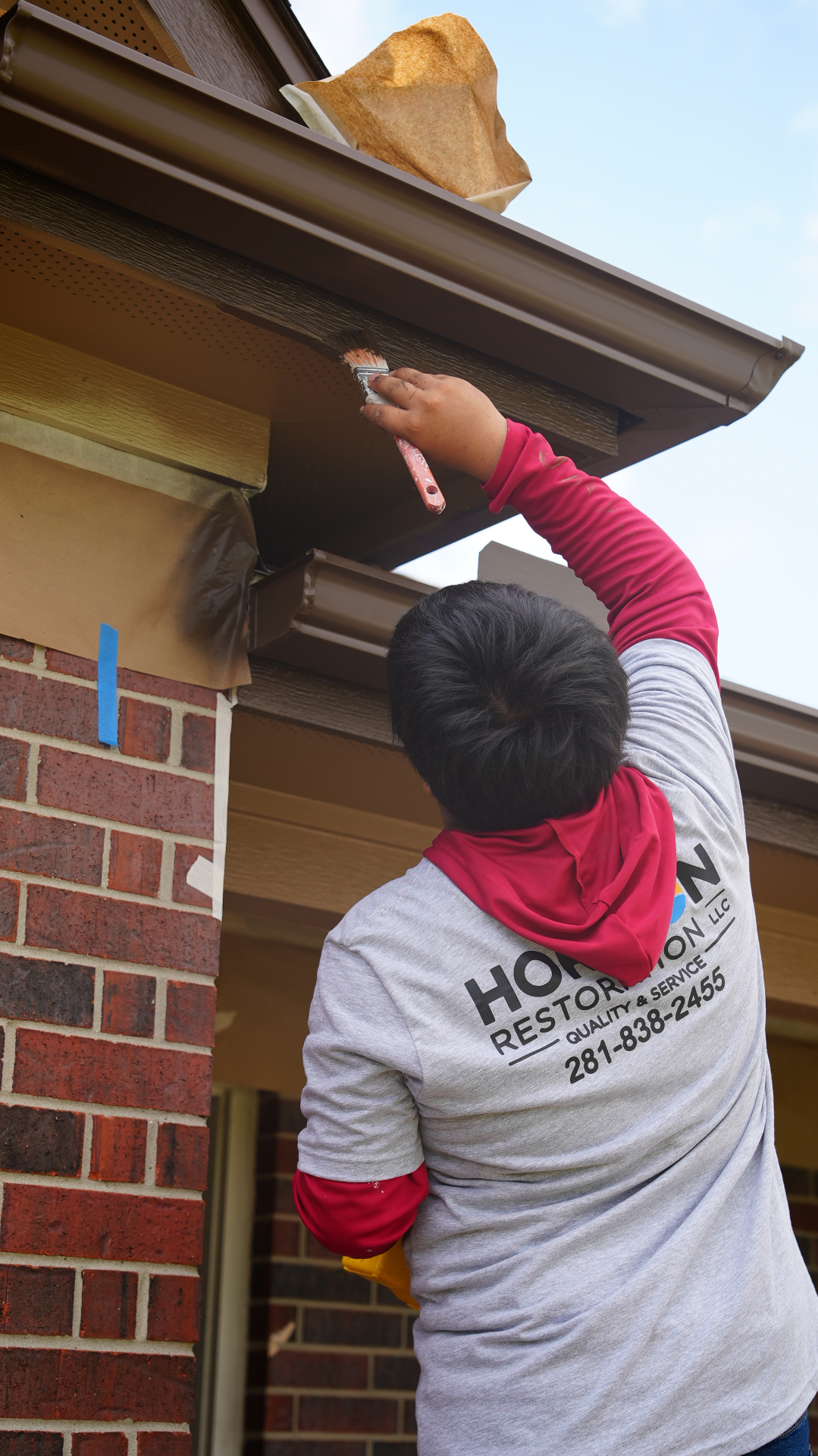 Brushing freshly prepped soffit and fascia by hand